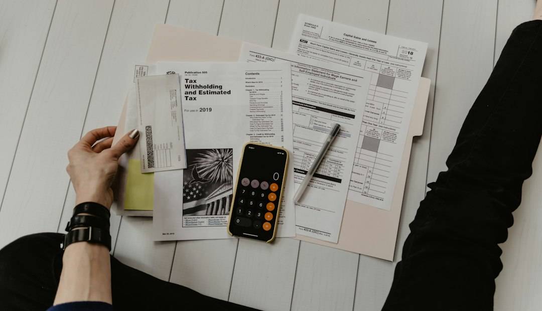 A person reviewing household finances with a calculator, paper and pen