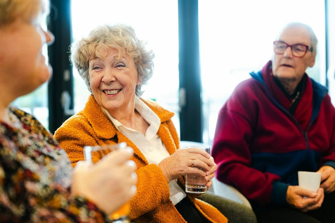 Three older adults smiling and talking together, representing social connection
